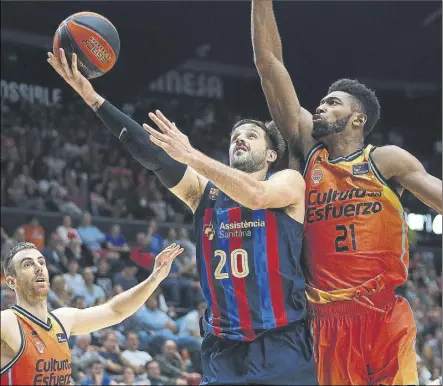  ?? Foto: EFE ?? Nico Laprovitto­la deja la bandeja ante Claver y Alexander. Los puntos del argentino despegaron al Barça en la primera mitad