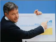  ?? (AP/Markus Schreiber) ?? German Economy and Climate Minister Robert Habeck points to a poster with a graphic detailing wind energy and photovolta­ic expansion Tuesday during a news conference about the German government climate policy in Berlin.