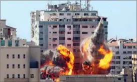  ?? ASHRAF ABU AMRAH / REUTERS ?? The al-Jalaa building, which housed The Associated Press and Al-Jazeera media offices, is hit by an Israeli airstrike in Gaza on May 15. The building was destroyed.