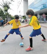  ??  ?? Brincadeir­a. Garotos jogam futebol