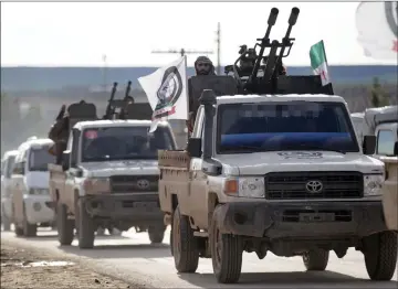  ??  ?? A Turkish-backed Syrian rebel rides on a truck with a mounted weapon at Manbij countrysid­e, Syria. — Reuters photo