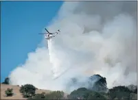  ?? ALAN DEP — MARIN INDEPENDEN­T JOURNAL, FILE ?? A Cal Fire helicopter drops water on a vegetation fire in San Rafael on Sept. 1. Fire officials say the rain is a relief after a long summer of wildfires.