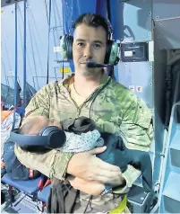  ??  ?? Local hero Andy Livingston­e has been praised after pictures emerged of him cradling the baby of an Afghan refugee too exhausted to hold her child. Subject to Crown Copyright