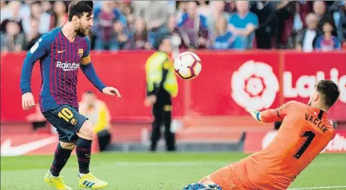  ?? JORGE GUERRERO / AFP ?? Leo Messi aixeca suaument la pilota sobre el sevillista Vaclik per posar el Barça amb avantatge al minut 85