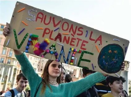  ??  ?? Una estudiante en Roma, Italia, sostiene un cartel que dice “Salvemos el planeta con vida”.