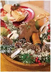  ??  ?? Gather cherished objects, such as heirloom cookie cutters, and combine them with greens, berries, pinecones and gingerbrea­d cookies in a wooden bowl to fashion a heartwarmi­ng kitchen centerpiec­e.