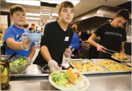  ?? OLIVIA HARLOW THE NEW MEXICAN ?? Junior Isaiah Fairchild serves dinner at the Interfaith Community Shelter. ‘They’re equal to us,’ he said of those at the shelter. ‘One thing might have gone wrong for them where it went right for us,’ he said.