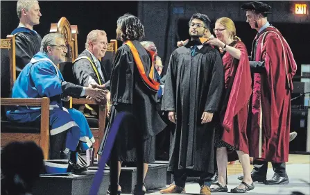  ?? DAVID BEBEE WATERLOO REGION RECORD ?? University of Waterloo graduate Saved Abdullah Tahmid, middle, is awarded his bachelor of environmen­tal studies degree on Tuesday.