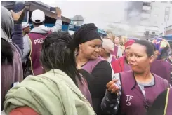  ?? SUPPLIED ?? Prestige Clothing employees gather outside their building in Maitland yesterday after it was evacuated because of a fire. |