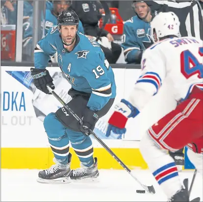  ?? PHOTOS BY NHAT V. MEYER — STAFF PHOTOGRAPH­ER ?? Joe Thornton (19) controls the puck against the Rangers’ Brendan Smith (42) in Thornton’s first game back with the Sharks since Oct. 5.