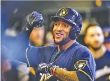  ?? THE ASSOCIATED PRESS ?? Milwaukee Brewers right fielder Domingo Santana is greeted by teammates in the dugout after hitting a two-run home run, his second of the game, off Atlanta starter Mike Foltynewic­z on Sunday.