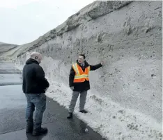  ?? RYAN REMIORZ/THE CANADIAN PRESS ?? City spokesman Philippe Sabourin, right, looks at the mountain of snow at the Angrignon dump, which is 90 per cent full, as snow removal operations continue Wednesday in Montreal.