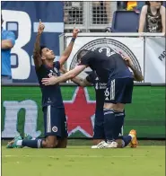  ?? AP FILE ?? Revolution midfielder Dylan Borrero, center, celebrates the goal scored by teammate forward Gustavo Bou during their match against Sporting Kansas City on June 12.