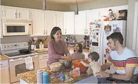  ?? DARIO LOPEZ-MILLS/AP ?? Katherine Rutigliano prepares a meal with her husband, Elio, along with their son, Theo, and daughter, Charlotte, at their home just outside Phoenix. When the couple moved from San Francisco in 2013, they figured they would never meet a fellowDemo­crat again.