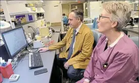  ?? Lake Fong/Post-Gazette ?? Cornelius J. Clancy, associate professor of medicine in the University of Pittsburgh’s Division of Infectious Diseases, discusses a yeast infection result with Susan Liegey, a lead medical technologi­st, at the UPMC Clinical Laboratory in Oakland.