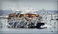  ?? STEVE HELBER — THE ASSOCIATED PRESS ?? A cargo ship stuck under the Francis Scott Key Bridge after the ship hit the bridge March 26 in Baltimore, Md.