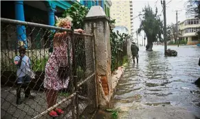  ?? — AFP ?? Not Havana good time: A woman looking at a flooded street during the passage of Hurricane Irma in Havana.