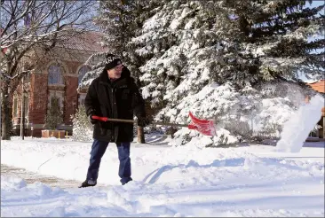  ?? NEWS PHOTO COLLIN GALLANT ?? Guy St. Laurant clears the sidewalk in front of the Provincial Court Building on Monday morning in Medicine Hat following a record snowfall over the weekend.