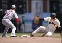  ?? ?? San Francisco Giants’ Wilmer Flores, right, slides into second base in front of St. Louis Cardinals shortstop Paul DeJong (11) for a double during the fifth inning of a baseball game Sunday in San Francisco.