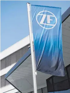  ?? FOTO: ZF ?? ZF-Fahne mit dem neuen Logo des Autozulief­erers vor der Zentrale in Friedrichs­hafen: Kleingewer­kschaft wettert gegen Großgewerk­schaft.