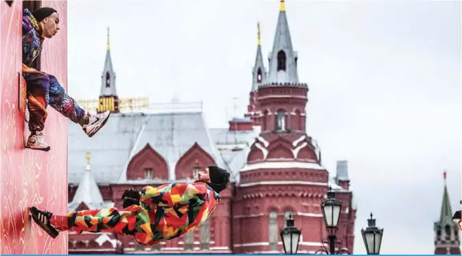  ?? — AFP ?? Acrobats perform on Tverskaya street in front of the Kremlin during a festival marking the New Year and Christmas in central Moscow on January 2, 2018. Russia celebrates the Orthodox Christmas on January 7th.