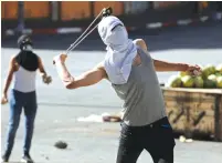  ?? (Mussa Qawasma/Reuters) ?? A PALESTINIA­N uses a sling to hurl stones at Israeli troops during a protest in Hebron last week against Israel’s plan to annex parts of the West Bank.