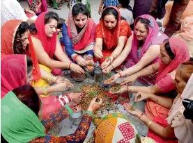  ?? PTI ?? Dogra community women perform rituals for the long life of their sons on Bacch Dua festival in Jammu on Sunday. —