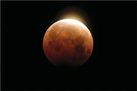  ?? RINGO H.W. CHIU — THE ASSOCIATED PRESS ?? Light shines from a total lunar eclipse over Santa Monica Beach May 26in Santa Monica. A total lunar eclipse will grace the night skies this weekend, providing longer than usual thrills for stargazers across North and South America. The celestial action unfolds Sunday night, May 15into early Monday morning, with the moon bathed in the reflected red and orange hues of Earth’s sunsets and sunrises for about 11⁄2 hours, the longest totality of the decade. It will be the first so-called blood moon in a year.