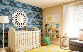  ??  ?? John Woodcock/J and J Design Group via AP This boy’s room takes its cue from the past, and features a wall with a big, ’70s-style geometric design, balanced with a similarly bold rug. The vibrant wallpaper sparks the child’s imaginatio­n. Grown-up...