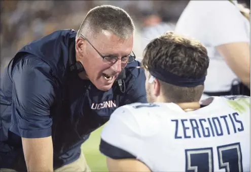  ?? Phelan M. Ebenhack / Associated Press ?? UConn coach Randy Edsall, left, talks to quarterbac­k Jack Zergiotis on the bench during the first half against Central Florida in 2019.