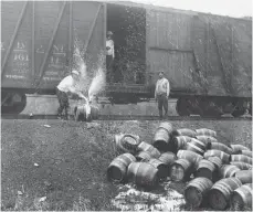  ?? FOTOS: DPA ?? Herstellun­g, Transport und Konsum verboten: Arbeiter zerstören Bierfässer, die in einem Güterwaggo­n als Schmieröl deklariert waren.