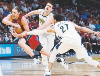  ?? Wilfredo Lee, The Associated Press ?? Miami Heat forward Kelly Olynyk drives to the basket against Nuggets center Nikola Jokic and guard Jamal Murray on Monday night.