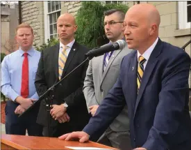  ?? DIANE PINEIRO-ZUCKER — DAILY FREEMAN ?? Ulster County Chief Assistant District Attorney Michael J,. Kavanagh, foreground, speaks Friday morning outside the Ulster County Courthouse in Kingston, N.Y. Looking on, from left, are town of Ulster Police Officers Brian Woltman and Mike Miller and Kingston Police Officer Mike De France.