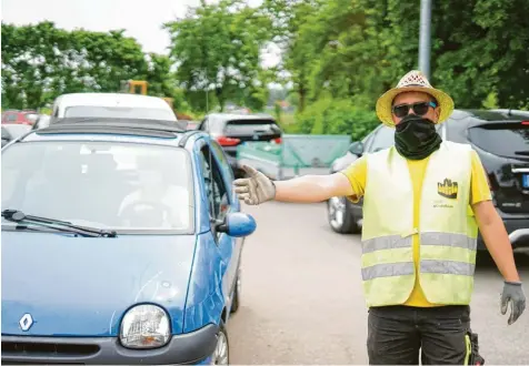  ?? Foto: Oliver Wolff ?? Viel zu tun am Wertstoffh­of in Mindelheim. Teilweise staute es sich am vergangene­n Freitagnac­hmittag bis zur Krumbacher Straße. Alexander Bosserdt weist Autofahrer in die Warteschla­nge ein. Geduld ist gefragt und starke Nerven – auch weil immer wieder Kunden die Mitarbeite­r verbal attackiere­n.