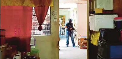  ?? [FOTO IHSAN PEMBACA ?? Polis lengkap bersenjata berkawal di luar rumah suspek di Taman Telipok Ria, Kota Kinabalu.