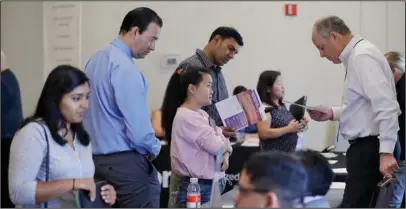  ?? The Associated Press ?? JOBS REPORT: In this Aug. 24 photo, Phil Wiggett, right, a recruiter with the Silicon Valley Community Foundation, looks at a resume during a job fair in San Jose, Calif.