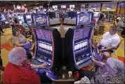  ?? GENE J. PUSKAR — ASSOCIATED PRESS FILE ?? In a 2013 photo, people play some of the 600 slot machines at the Lady Luck Casino Nemacolin shortly after its grand opening in Farmington, Pa.