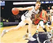  ?? ANDREW SHURTLEFF AP ?? Virginia forward Sam Hauser drives past Miami guard Elijah Olaniyi on his way to 18 points on Monday.