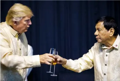  ?? THE ASSOCIATED PRESS ?? President Donald Trump toasts Philippine­s President Rodrigo Duterte, right, Sunday at an ASEAN Summit dinner at the SMX Convention Center in Manila, Philippine­s.