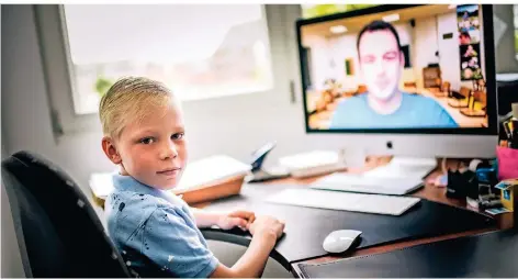  ?? RP-FOTO: ANDREAS BRETZ ?? Anton Schäfer geht in die 2b der Grundschul­e Fleher Straße. Sein Lehrer Alexander Grote (auf dem Bildschirm) unterricht­et auch per Video.