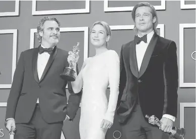  ?? — Gambar AFP ?? MENYERLAH: Phoenix (kiri) bersama pelakon Renée Zellweger dan Brad Pitt (kanan) menunjukka­n anugerah Oscar.