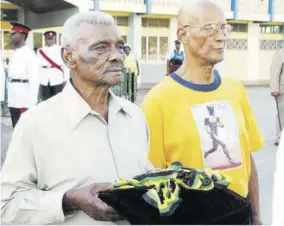  ??  ?? Jamaican Olympians Leslie Laing (left), a member of Jamaica’s 4X400 metres record-setting, gold medal winning-team at the 1952 Helsinki Olympics, along with Byron Labeach as they departed the National Arena following the funeral service for the great Herb Kckenley in this 2007 file photo. Here, Laing carries Mckenley’s Olympic medals.