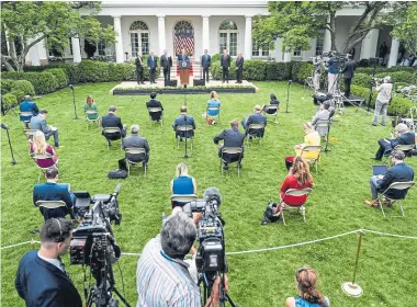  ?? Erin Schaff, © The New York Times Co. ?? Physically distanced journalist­s listen to President Donald Trump speak Friday at the White House Rose Garden.