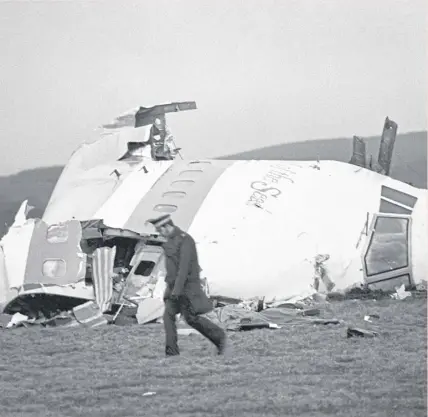  ?? ?? ↑ A police officer walks near the wrecked nose section of the Pan-am flight 103 in Lockerbie in December 1988