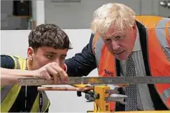  ?? ?? Der britische Premier Boris Johnson in einer Schule zur Berufsausb­ildung: Die Unternehme­n ächzen unter hohen Energiekos­ten.
