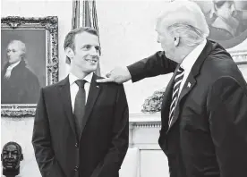  ?? AFP ?? Ante los periodista­s, Trump le quitó una supuesta caspa de la solapa a Macron.