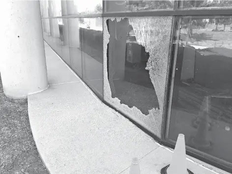  ?? Lexington Herald-Leader/TNS ?? An apparent bullet hole mars one of the press room windows Sunday in the Lexington Herald-Leader building in Lexington, Ky. Several exterior windows were damaged on the first-, second- and third-level banks of windows of the press room on the Midland...