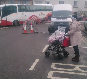  ??  ?? Mrs. Bannon trying to cross a busy Sligo Street with a buggy last Thursday afternoon.