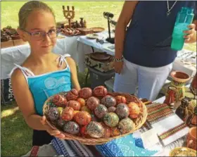  ?? PAUL POST — PPOST@DIGITALFIR­STMEDIA.COM ?? Sofia Lozynska displays a basket of pysanky, or hand-painted wooden Ukrainian eggs.