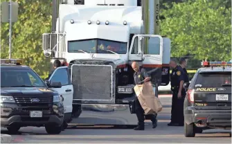  ?? ERIC GAY AP ?? San Antonio police investigat­e the scene where eight people were found dead Sunday in a tractor-trailer loaded with at least 30 others. A ninth person died at after arriving at a local hospital.